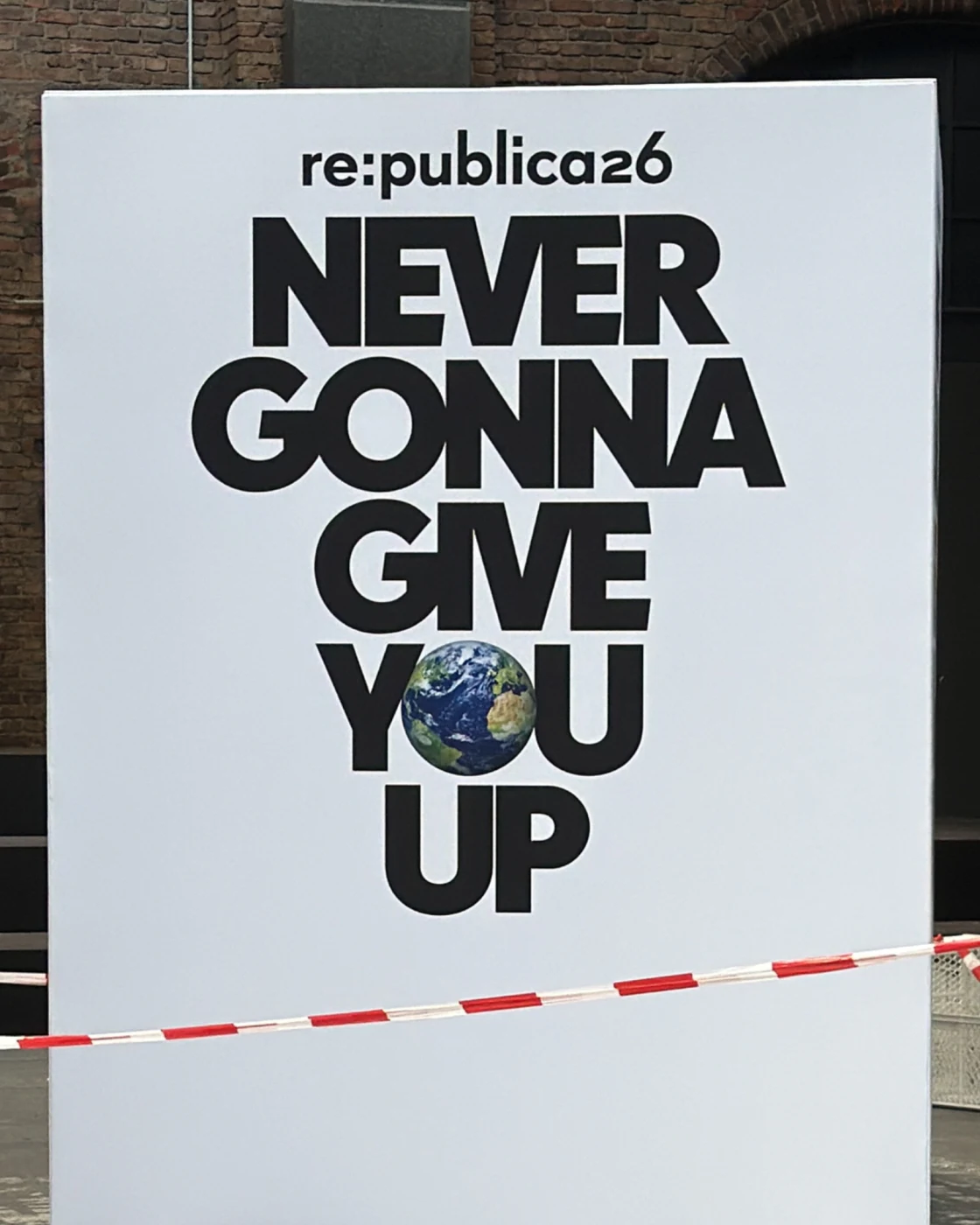 re:publica 2026 stage poster reading 'never gonna give you up', with planet Earth forming the letter O